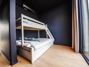 a bedroom with a white bunk bed in a room at La Rurée in Heure