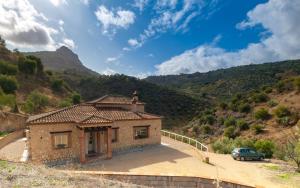 a house with a car parked in front of a mountain at Villa 294 by Villamya in El Gastor