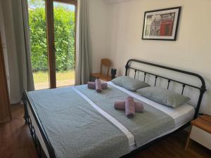 een slaapkamer met een bed met 2 roze kussens erop bij Rustic house with private swimming pool in Pula +23 foto's