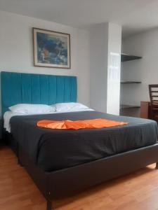 a bed with a blue headboard in a room at Hotel Roma Bogota , Corferias , Cerca Embajada Americana , Universidad Nacional , G 12 ,Movistar Arena Agora Habitaciones y Apartaestudios muy bien ubicado a 30 minutos del Aeropuerto in Bogotá