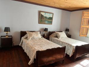 une chambre avec deux lits et un tableau au mur dans l'établissement Hostal Casa Rosada, Valle del Elqui, à Rivadavia