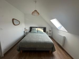a bedroom with a bed in a white room at Maison à Dol de Bretagne in Dol-de-Bretagne