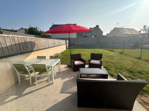 a patio with a table and chairs and an umbrella at Maison à Dol de Bretagne in Dol-de-Bretagne