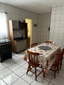 a kitchen with a table and chairs and a kitchen with a stove at Taba House in São Gabriel