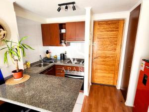 a kitchen with a sink and a counter top at Central Departamento 1D Frente a Mall - Estacionamiento in Antofagasta