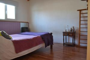 a bedroom with a bed and a wooden floor at Casa Hábitat - Habitaciones en casa compartida con baño privado in San Martín de los Andes