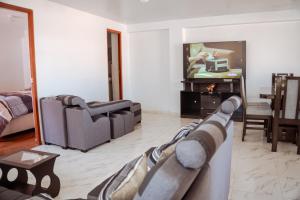 a living room with a couch and a tv at duplex acogedor in Cusco