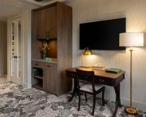 a hotel room with a desk and a television at Rosemead House in Victoria