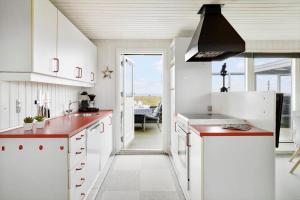 a kitchen with white cabinets and red counter tops at 40164-Juelsminde-Hybenvej-17 in Juelsminde +24 photos