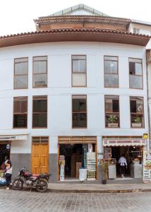a white building with motorcycles parked in front of it at duplex acogedor in Cusco