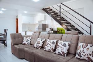 a living room with a brown couch with pillows at duplex acogedor in Cusco
