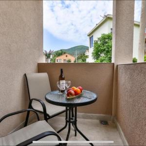 a table with a bottle of wine and fruit on a balcony at Villa Kosta in Budva +43 photos
