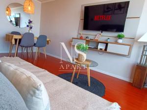 a living room with a couch and a tv at NORTH SUITE - Vista al Mar Centricos Dptos Frente al Mall in Antofagasta