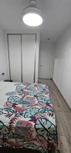 a bedroom with a bed with a colorful blanket on it at Ático con Terraza Feria Albacete in Albacete