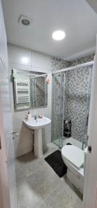 a bathroom with a toilet and a sink and a shower at Ático con Terraza Feria Albacete in Albacete +6 photos