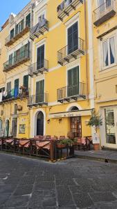 a yellow building with benches in front of it at Il Balcone sul Castello in Ischia