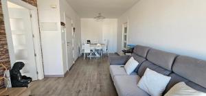a living room with a gray couch and a table at Ático con Terraza Feria Albacete in Albacete