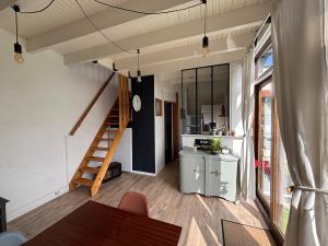 una camera con scala e tavolo e una cucina di Logement indépendant a Saint-Didier-au-Mont-dʼOr