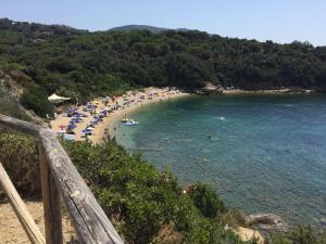 a beach with umbrellas and people in the water at Villetta Grazia in Capoliveri