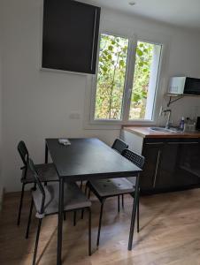 a kitchen with a table and chairs in a kitchen at Cottage near Clisson in Gétigné +4 photos
