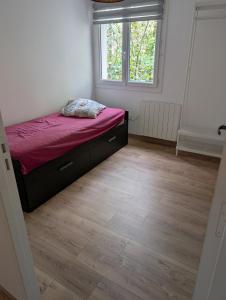 a bedroom with a bed and a window and a wooden floor at Cottage near Clisson in Gétigné