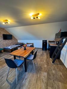 a dining room with a wooden table and chairs at Sklep u Havlíků in Mutěnice