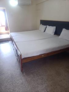 Ένα ή περισσότερα κρεβάτια σε δωμάτιο στο Sri Kumaran Lodge & Hall