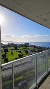 a balcony with a view of a road and the ocean at Atlantic Golden View Luxe Apartment in Ponta Delgada