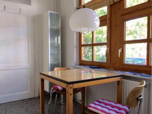 a kitchen with a table and chairs and windows at Art-Apartment-Leo in Bremerhaven