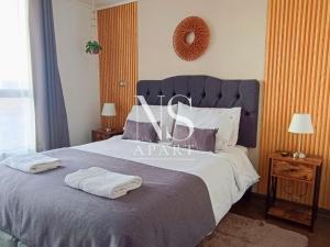 a bedroom with a large bed with two towels on it at NORTH SUITE - Departamento con Vista al Mar- Parking y Piscina-Cercano a Mall la Portada in Antofagasta