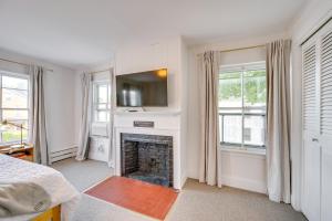a bedroom with a fireplace with a tv above it at 15 Mi to Stowe Mountain Resort Main Street Studio in Waterbury