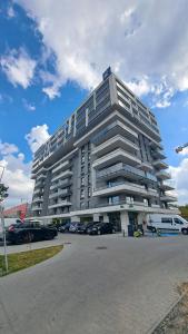 a large building with cars parked in a parking lot at 9th Floor Apartament 95 - obok galerii echo in Kielce