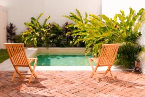two chairs sitting next to a swimming pool at Casa Chicatana in Puerto Escondido