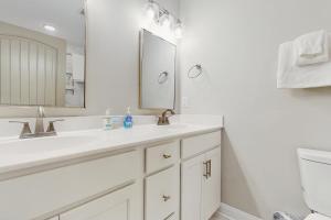 a white bathroom with a sink and a mirror at Beaufort Villas #A in Beaufort +12 photos