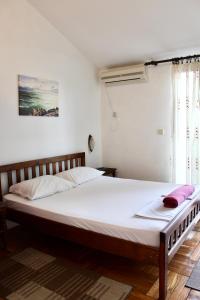 ブドヴァにあるGuest House Mandarinaの白いシーツが敷かれた大きなベッドのある寝室