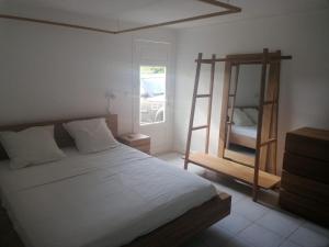 a bedroom with a bed with a ladder and a mirror at Very nice villa with pool, sea view, large land in Le Gosier