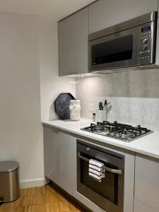 a kitchen with a stove and a microwave at Cozy Gastown condo with a view! in Vancouver +16 photos