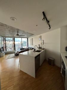 a kitchen with a sink and a living room at Cozy Gastown condo with a view! in Vancouver