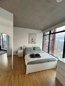 a bedroom with a large bed and a large window at Cozy Gastown condo with a view! in Vancouver