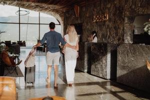 a man and woman walking through a airport with their luggage at Böden Hotel & Spa, AKEN SOUL in Villa General Belgrano