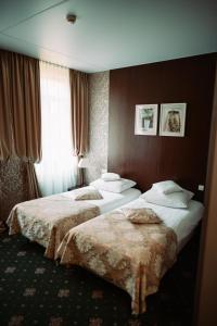 a hotel room with two beds and a window at Villa Tradycja in Białystok +30 photos