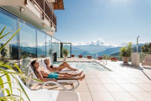 zwei Frauen in Badeanzügen liegen auf Stühlen am Pool in der Unterkunft Hotel Monte Bondone in Vaneze + 61 Fotos