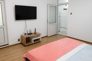 a living room with a flat screen tv on a wall at Justin Ultra-Central Apartment in Galaţi