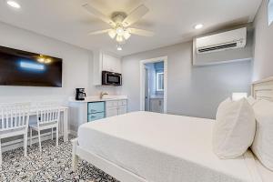 a bedroom with a white bed and a kitchen at Sweet Studio Suite in Rockport +8 photos