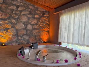 a bath tub in a room with a stone wall at Manzara Bungalov in Fethiye