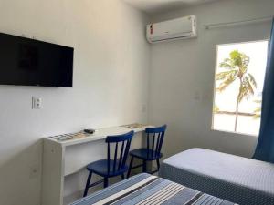 a bedroom with two chairs and a desk with a tv at Apart Hotel Marinas Tamandaré - apt 304 in Tamandaré