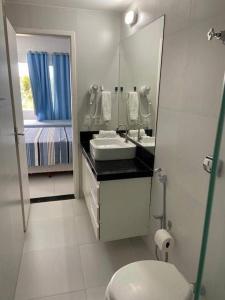 a white bathroom with a sink and a toilet at Apart Hotel Marinas Tamandaré - apt 304 in Tamandaré