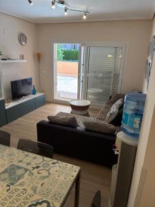 a living room with a couch and a tv at Apartamento de lujo en Canet de Berenguer a 150 m de la playa in Canet de Berenguer