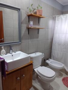 ein Badezimmer mit weißer Toilette und Waschbecken in der Unterkunft Santa María alojamiento in Federación