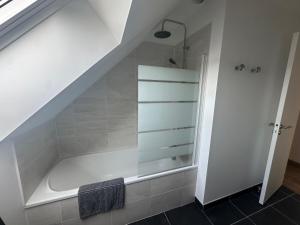 a bathroom with a bath tub under the stairs at Maison à Dol de Bretagne in Dol-de-Bretagne +14 photos